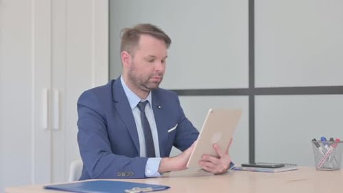 Cheerful Businessman using Tablet PC