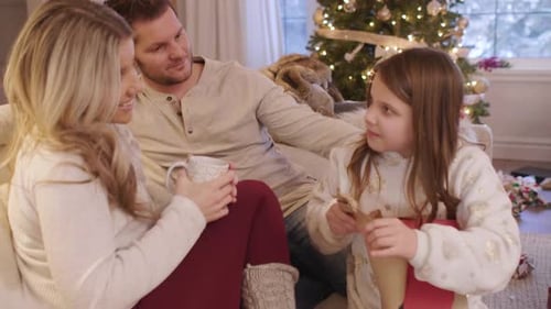 Family Celebrating Christmas Together with a Present