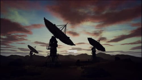 Satellite Dishes On Field Against Cloudy Sky During Sunset