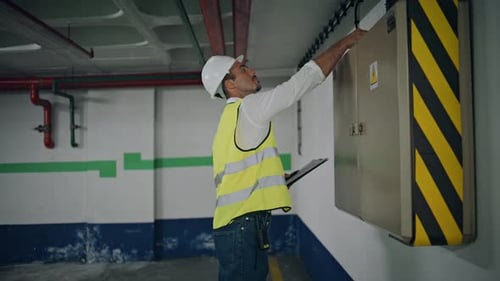 Electrical Technician Checking Communications Parking Lot Zoom on Man Working