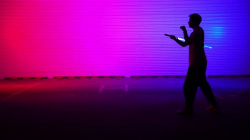 Une silhouette époustouflante avec des néons éclatants et un sabre laser saisissant dans un cadre artistique