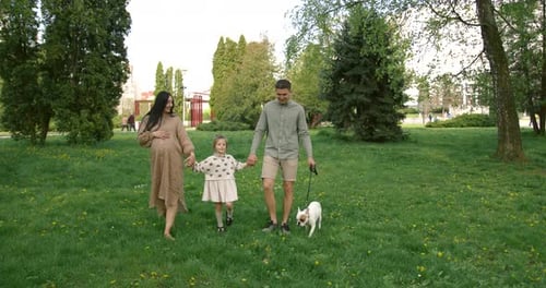 Happy Family Walking with Dog in Park