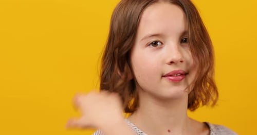 Portrait d'une écolière adolescente attentionnée sur un fond jaune vif