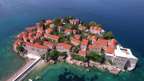Drone Shot of Sveti Stefan Island, Montenegro. Luxury Resort With Old Stone Houses and Buildings