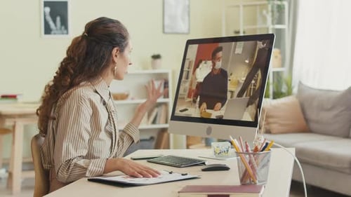 Businesswoman Video Chatting with Office Colleagues on Computer