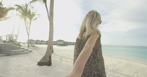 POV-Filmmaterial. Schöne Frau, die Händchen mit ihrem Freund hält und in Richtung Meer rennt. Weißer Sand,
