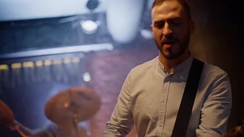 Inspired Musician Playing Guitar with Rock Band on Nightclub Stage Closeup