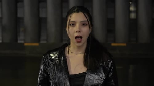 Stylish Young Woman Speaking in City at Night