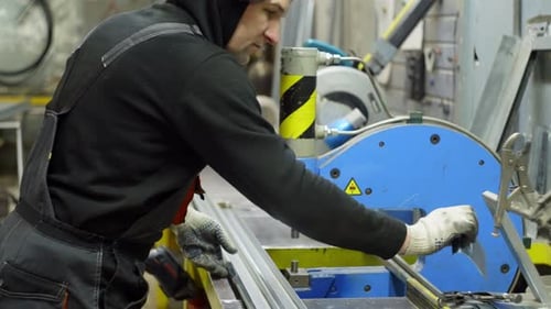 Professional Metalworker Cutting and Shaping Metal Profiles in a Factory