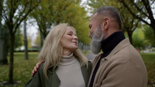 Mature Couple Embrace Affectionately in the Autumn Park