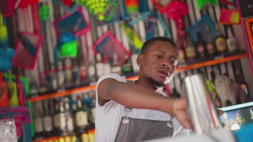 Barman Takes Shaker and Glass in Club