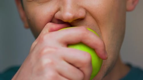 Face Portrait of Adult Man Eating Healthy Food of Green Apple in CloseUp Shot