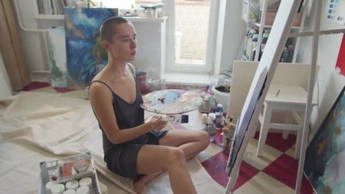 Young Adult Woman Painting in her Art Studio