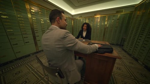 A Man and a Woman are Sharing a Table in a Bank Building