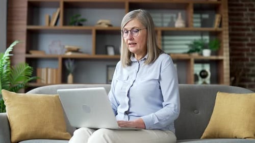 Senior Woman Video Calling on Laptop in Living Room