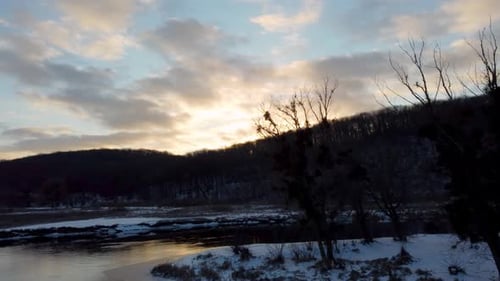 Winter view on river with scenic sunset reflection
