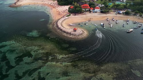 Drone Footage of Tropical Beach Lagoon with Curved Breakwater, Fishing Boats and People Swimming