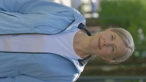 Woman Smiling in Park Wearing Blue Jacket