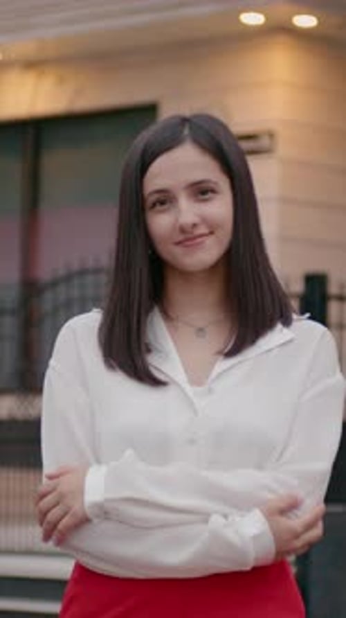 Young Woman Smiling with Arms Crossed Outdoors