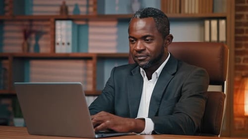 Focused Executive Businessman Working in Office Typing on Laptop Reads Good News By Email Successful