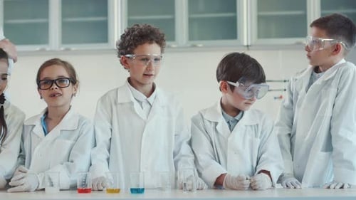 Children in Lab Coats Doing Science Experiment