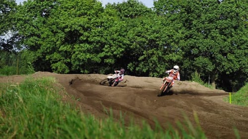 Motorcycles Racing on a Dirt Track on a Sunny Day