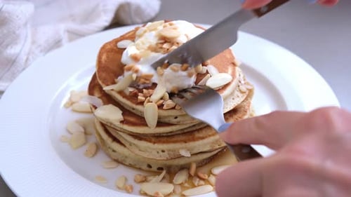 Stack of Pancakes Being Cut With Knife and Fork