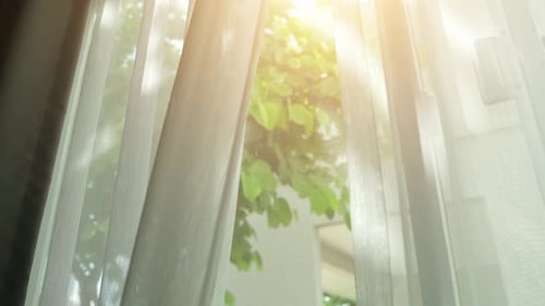 Opening the curtains to let in natural sunlight fills the room.