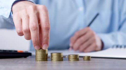 Woman Stacking Gold Coins for Financial Growth