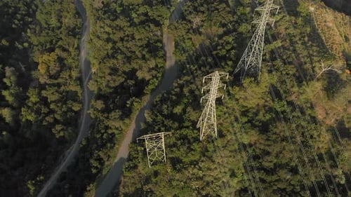 Aerial Rotation Around Power Lines on a Verdant Mountain
