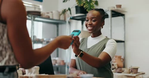 Woman Pays with Mobile Reader in Storefront