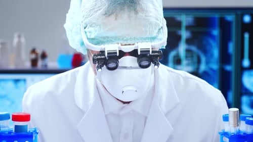 Scientist in Lab Coat Examining Test Tubes