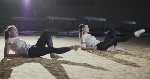 Women Performing Leg Lifts in a Gym