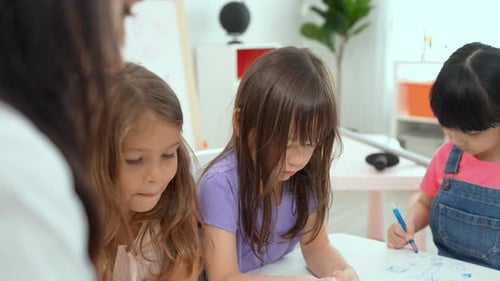 Children Drawing With Their Teacher in Classroom