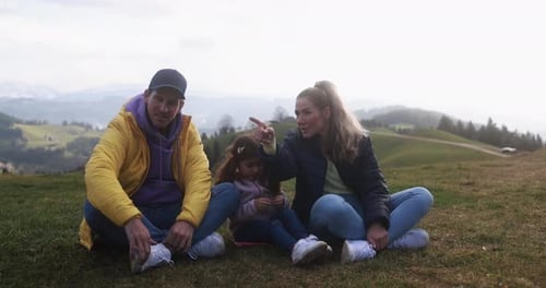 Happy young family takes a break on a hiking trip in the swiss mountains