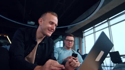 Mature young men using modern technologies. Man looks at his laptop intently.