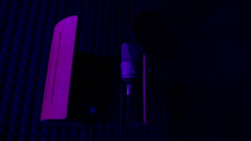 professional recording studio song recording equipment microphone close-up bottom view purple neon