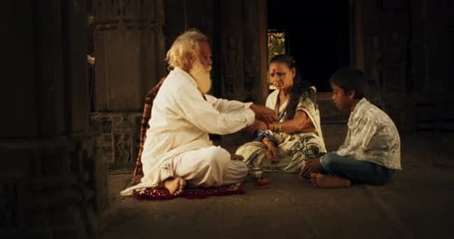 Vidéo authentique d'un prêtre hindou attachant un fil mauli autour de celui d'une adepte du temple