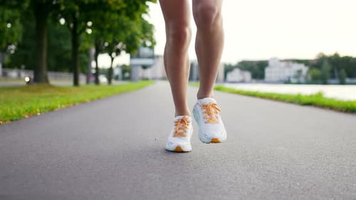 Slow Motion Video of a Girl Jogging in a City The Athlete is Engaged in Training Fitness Outdoors