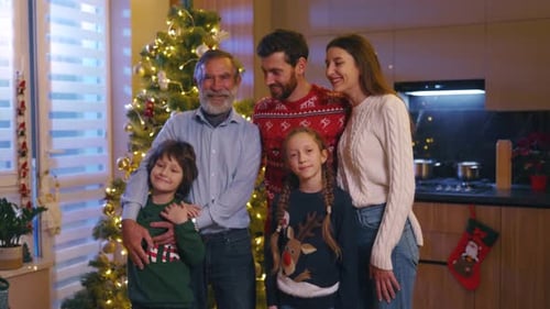 Multi-Generation Family Posing Together by Christmas Tree Indoors