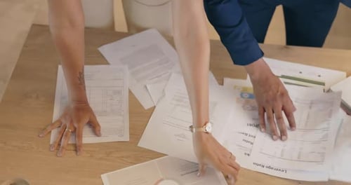 Close-Up Top View of Business People Planning with Paperwork at Table