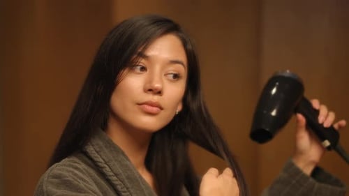 Woman Dries Long Dark Hair with Hair Dryer