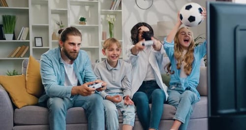 Family Playing Video Games on Couch in Living Room