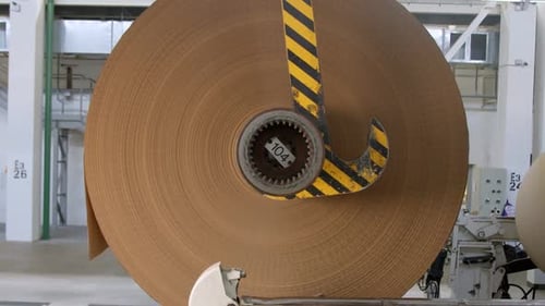 Lifting Up Coil of Brown Packaging Paper in Plant Workshop