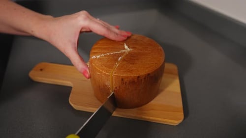 Female hands cutting cheese to extract one piece, 4K