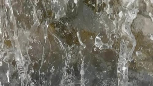 Close up of waterfall in slow motion, camera slowly follows flow of water