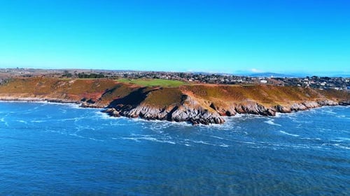 The scene shows a coastal area with rocky cliffs and deep blue water.