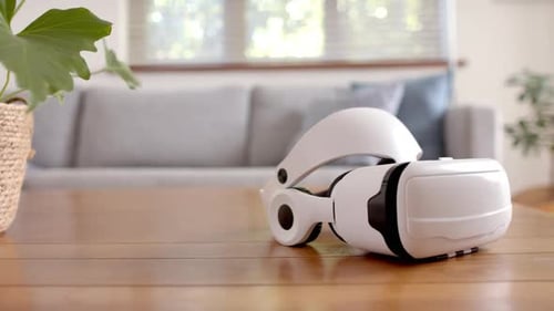 Virtual reality headset resting on wooden table in modern living room, at home, copy space