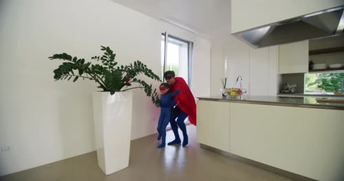 A carefree happy smiling father and daughter dressed as superheroes are having fun to run and jump