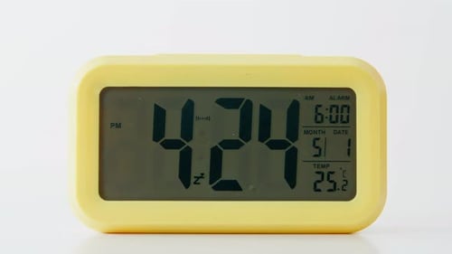 Closeup Electric Clock Display Showing Time and Date Modern Yellow Timepiece